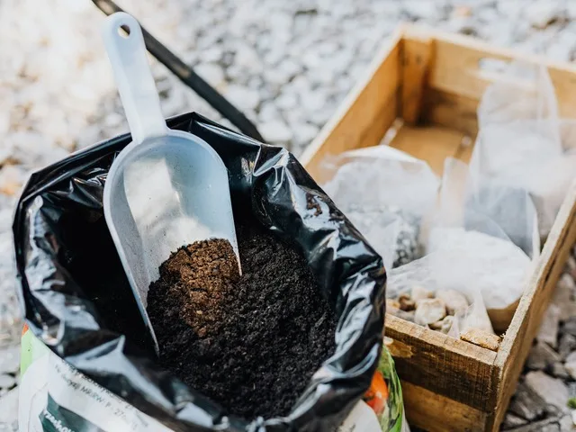Virágföld zsák és ültetőlapát vetőmagos ládák mellett